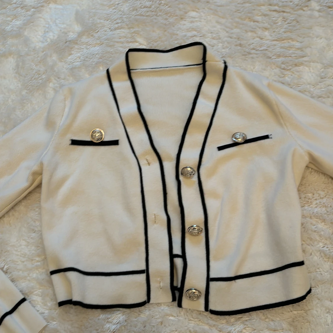 Vit kofta med svarta detaljer 