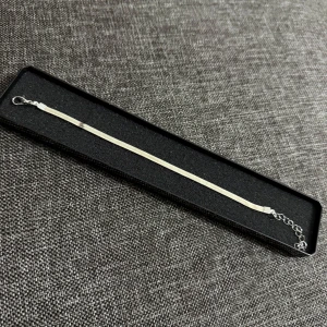 Tunt silverfärgat armband - Stilrent och smalt armband i silverfärg med platt kedja och justerbar längd. Armbandet har en enkel karbinhake och passar perfekt för dig som gillar minimalistiska smycken. Levereras i svart ask. Helt nya oanvända Vid retur står köparen för Frakten/Returen. Jag ansvarar inte för postens slarv.