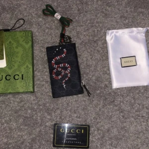 GUCCI halsplåmbok  - Gucci plånbok som man kan ha runt halsen. Den är hyfsat ny men har aldrig använt den. Den är äkta. Allting på bilderna medföljer! Skickas samma dag