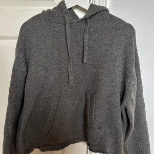 Grå stickad hoodie från Zara - Mysig grå stickad hoodie från Zara med huva och snörning. 
