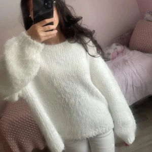 Fluffig vit stickad tröja - Världens mysigaste vita stickade tröjan med fluffigt garn och oversized passform. Tröjan har långa ärmar och en enkel rund halsringning. Perfekt för att hålla sig varm och ändå se stilren ut. Passar dig som gillar en chill och cozy vibe. Pris kan diskuteras 💕