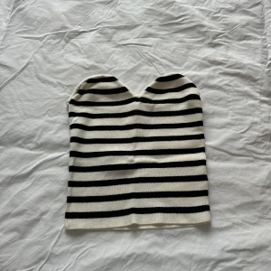 Randig bandeau topp - Säljer en snygg bandeau tubtopp med svartvita ränder från H&M i strl xs. Helt i nyskick, bara använd en gång!🩷