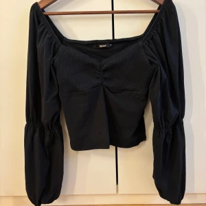 Svart blus med puffärmar  -  svart blus  med bred, fyrkantig urringning och puffiga långärmar. 