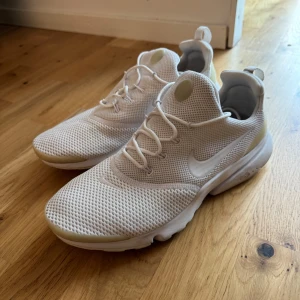 Vita Nike Presto sneakers strl 42 - Snygga vita Nike Presto sneakers med mesh-ovandel och klassisk swoosh på sidan. Skorna har rund tå, snörning och platt sula för en clean och sportig look. Perfekta för dig som gillar stilrena och bekväma sneakers till vardags.