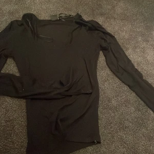 Svart långärmad topp Gina Tricot - Svart långärmad topp från Gina Tricot i storlek M. Tunn och stretchig med rund halsringning och smal passform. Perfekt att styla med jeans eller kjol för en clean look. Materialet känns mjukt och följsamt mot kroppen. Den är även sydd på insidan men är ingenting man märker av