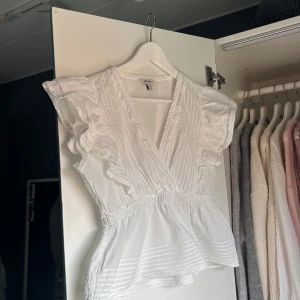 Vit volangblus - Så snygg vit v-ringad blus från Aware💗Den var längre i armarna, men har klippt av dem så den sitter bättre. Det syns inte när man har på sig den. Storlek M och passar S/M. Skriv vid frågor eller köp nu!