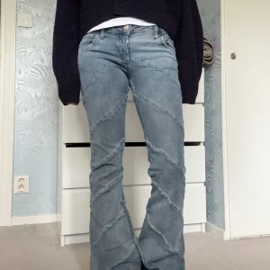 BDG ljusblå flare jeans med sömmar - Säljer ett par sjukt snygga ljusblå flare jeans från BDG Urban Outfitters. De har unika diagonala sömmar längs benen som ger en cool vibe. Modellen är lågmidjad och stretchig! De har dock lite slitningar i skrevet, men det syns knappt när man har på sig dom💗