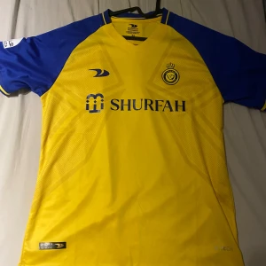 Al Nassr FC Ronaldo 7 gul/blå tröja - Al Nassr fotbolls tröja med Ronaldo på ryggen! Jätte bra skick nästan ny knappt använd. Pris kan diskuteras!