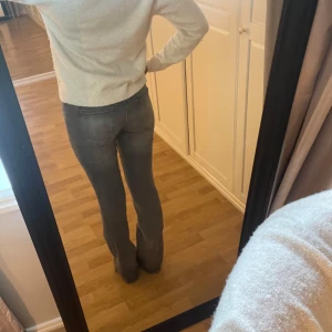 Grå bootcut jeans med låg midja - Säljer ett par grå low waist bootcut berska jeans i strl 36 som är supersnygga 