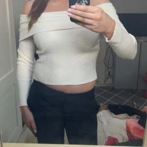Offshoulder ribbad topp från H&M - Säljer en snygg offshoulder topp från H&M i ribbad, ljusbeige bomullsmix. Toppen är croppad med långa ärmar och sitter tight. Perfekt för dig som gillar stilrena och trendiga plagg med en twist.