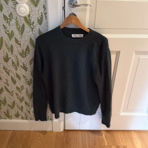 Mörkgrå stickad tröja Samsøe Samsøe - Snygg mörkgrå stickad tröja från Samsøe Samsøe med rund hals och ribbade muddar. Skick 6,5/10 använd och lite nopprig men inget större att anmärka på