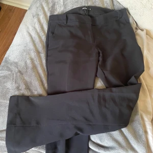 Svarta kostymbyxor från Bik Bok - Säljer ett par svarta kostymbyxor från Bik Bok. Byxorna har en klassisk rak passform med normal midja och är tillverkade i ett mjukt material som känns bekvämt hela dagen. Perfekta till både skola och jobb.