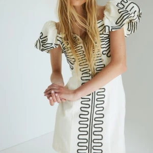 Vit klänning med puffärmar och svart mönster - Säljer denna klänning från hm, använd 1 gång🙌🏼🙌🏼sitter som s