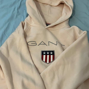 Beige/pink hoodie från GANT. 175  - Säljer en beige hoodie från GANT den är kön och cozy. Den är stylish och affordable size: 175/ 15 year old