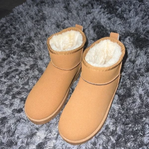 Beige fodrade boots - Säljer ett par bruna uggs med mjukt vitt foder. Skorna är helt oanvända. Är lite liten i storlek 💗