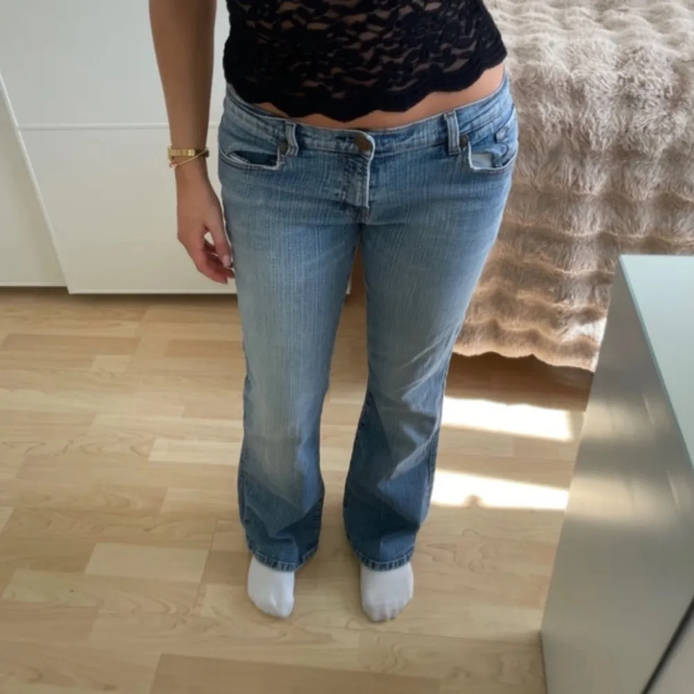 Snygga blå bootcut jeans med låg midja. Perfekta för en avslappnad stil. Klassisk design med fem fickor och knappgylf.. Farkut & Housut.