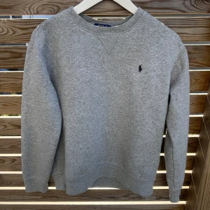 Ralph Lauren tröja grå - Säljer denna riktigt snygga Ralph Lauren tröja! Tröjan är i superfint skick och använd få gånger Inga defekter eller fläckar Strl 14-16y Passar 160-165 cm ungefär Perfekt nu till våren och sommaren!☀️ Tveka inte att höra av er vid funderingar😊 Priset kan diskuteras!🤝