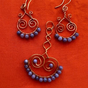 Handgjort smyckeset i koppar med blå pärlor - Unikt smyckeset med örhängen och halsband i snirklig koppartråd, dekorerade med blå pärlor. Perfekt för dig som vill sticka ut med ett bohemiskt och konstnärligt uttryck.