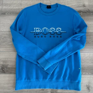 Blå tröja från Hugo Boss - En blå Hugo boss i väldigt fint skick. Storlek m. Använd 2 gånger. Köpt för 1200 på hede outlet. 
