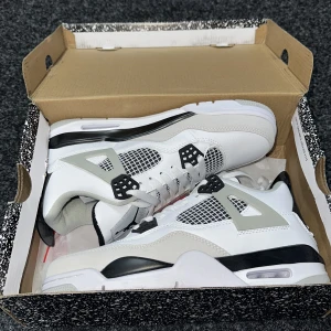 Nike Air Jordans vita och grå sneakers - Snygga Nike Air Jordans sneakers i vitt, grått och svart. Skorna har klassisk meshpanel, svarta och grå detaljer samt vit sula med synlig luftdämpning. 