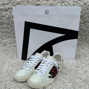 Gucci ace snake - Tja säljer nu ett par Gucci ace skor i storlek 41/42 26cm  med en orm på sidan som är väldigt populära, inga defekter förutom lite slitage av användning på sulorna med inget som påverkar skorna, men annars 10/10. Ny pris 9000, Inget OG följer med!! Skriv om du har några frågor och va inte rädd att lägg bud!!! Kolla måtten innan du köper om du är osäker!!  Byten funkar mot en större storlek!!!