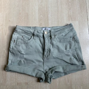 Gråa jeansshorts - Snygga gråa jeansshorts. Shortsen har slitna detaljer framtill, klassiska fickor. Perfekta för varma dagar och enkel att matcha med olika toppar. Passar både storlek S och M!
