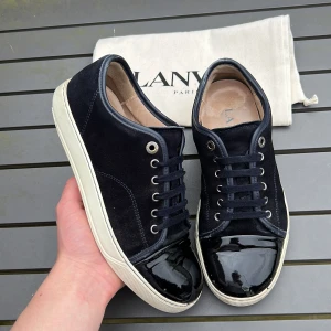 Lanvin - Säljer dessa sjukt feta lanvins i uk5 vilket motsvarar 39-40 men kan även passa 41! Lanvin sitter stort i storleken. Skick 8,5/10. Defekter? Slitet längst bak på båda sulorna. Vad ingår? Dustbag. Färg: navy blå. Hör av dig vid minsta fundering! Fraktar inom 24H 🤩