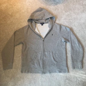 Ralph Lauren zip - Säljer en grå hoodie från Ralph Lauren med dragkedja och huva. 