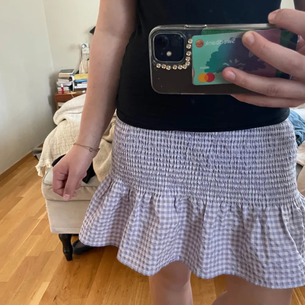 Säljer en söt lila rutig kjol från H&M:s Divided-kollektion. Kjolen har en volangdetalj längst ner och en elastisk midja för en bekväm passform. Perfekt för en avslappnad och stilren look.. Hameet.