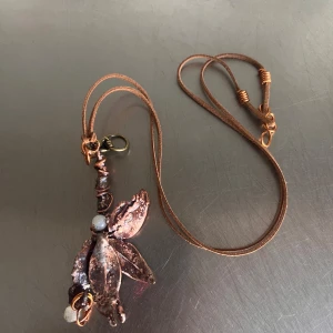 Halsband med bladformad hängare i koppar - Unikt halsband med en bladformad hängare i kopparfärg och små pärldetaljer. Hängaren har en organisk,    