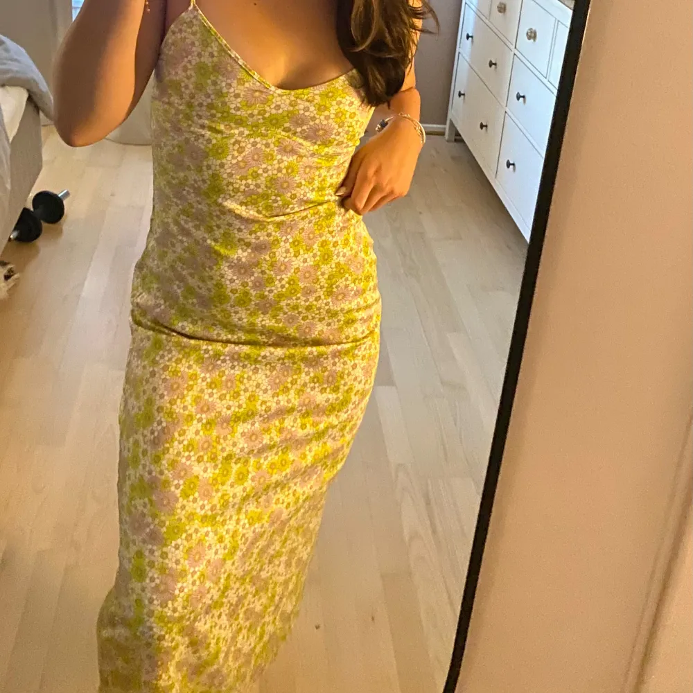 Säljer en blommig långklänning från Zara i grönt, vitt och lila. Klänningen har smala axelband, v-ringning och öppen rygg. Materialet känns lätt och svalt🌼. Mekot.