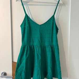 Grön playsuit  - Säljer en grön playsuit från H&M Divided med smala axelband och v-ringning!
