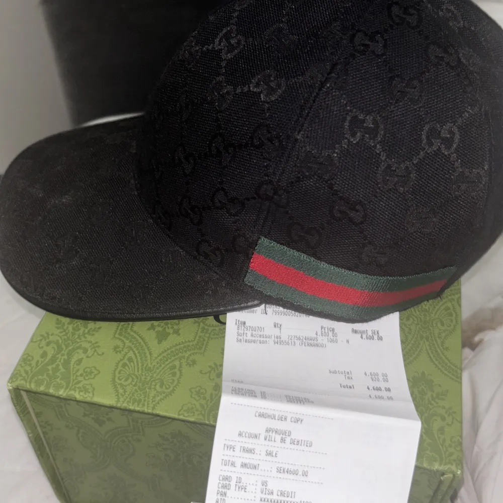 Säljer en svart keps från Gucci med klassiskt GG-mönster och grönt/rött band på sidan. Kepsen har böjd skärm och justerbar passform. Perfekt för dig som vill ha en stilren accessoar med lyxig känsla. Andvänd 1 gång. Asusteet.