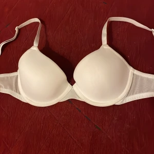 Vit bh från HM - Säljer en stilren vit bh med mjukt tyg och justerbara axelband. Perfekt för en bekväm och smidig passform, strolek 75A från HM. 
