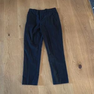 Svarta kostymbyxor från H&M - Snygga svarta kostymbyxor från H&M i slim fit med justerbar midja. Perfekta för en stilren look. Byxorna har en klassisk design med raka ben och är tillverkade i ett bekvämt material. Köpare betalar för frakt. Pris kan diskuteras!!