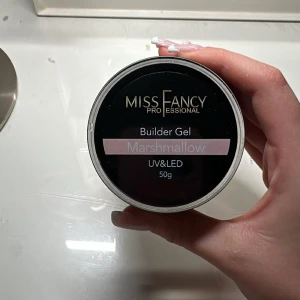 Builder Gel Marshmallow från Miss Fancy - Builder Gel i färgen Marshmallow från Miss Fancy, perfekt för att bygga starka och hållbara naglar. Gelen är rosa och kan härdas med både UV och LED. Förpackningen innehåller 50g. SLUT SÅLD PÅ SIDAN använd 1 gång 