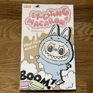 Exciting Macaron The Monsters Vinyl Face - Säljer en rolig och färgglad samlarfigur från Pop Mart, Exciting Macaron The Monsters. Förpackningen visar olika karaktärer som Sugar, Lemon Berry och Green Grape. Perfekt för samlare av unika och kreativa figurer!