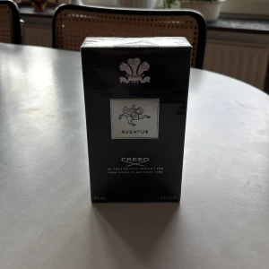 Creed Aventus Eau de Parfum 100 ml - Lyxig parfym från Creed, Aventus, i svart och silver förpackning. Flaskan rymmer 100 ml och är känd för sin fräscha och maskulina doft                         Säljs eftersom den inte kommit till avnänding 