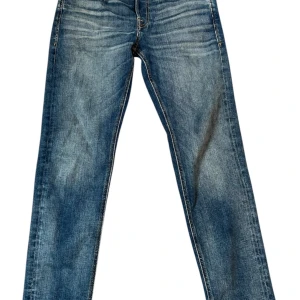 Jack & Jones blå tapered jeans 28/30 - Säljer ett par blå jeans från Jack & Jones i modellen Tapered/Mike. Storlek 28/30👍.Jeansen har klassisk femficksdesign, snygga slitningar och kontrastsömmar. Passformen är tapered med normal midja och raka ben. Perfekt för dig som gillar en avslappnad men stilren look. 9/10 skick🙌.  Det ända är en liten fläck på ena benet😁.