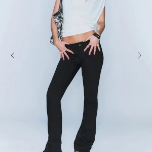 Säljer dessa eftertraktade jeansen från Cheap Monday - Svarta bootcut jeans från Cheap Monday med låg midja och klassisk femficksdesign. Byxorna har en tajt passform och ett lila logomärke bak i midjan. Perfekta för dig som gillar en clean och edgy look. Storlek 23/30