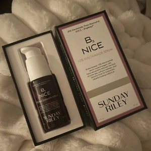 Sunday Riley B3 Nice Niacinamide Serum - Sunday Riley B3 Nice Niacinamide Serum med 10% niacinamid kommer i en mörklila pumpflaska på 30 ml. Vattenbaserat serum som jämnar ut hudtonen och minskar rodnad och porstorlek. Snygg förpackning med vit pump och stilren design.