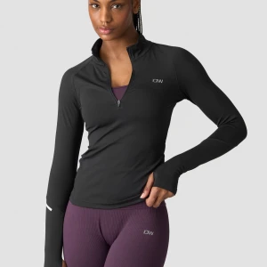 Svart långärmad träningströja ICIW - Svart långärmad träningströja från ICIW med half zip och tight passform. Tröjan har tumhål vid ärmsluten och reflekterande detalj på ärmen. Perfekt för löpning eller gym. Snygg och funktionell design med liten logga på bröstet. Aldrig använd!