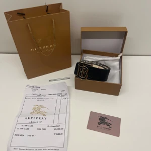 Burberry bälte  - Ett reversable burberry bälte vilket betyder att det går att vända den ut och in så du kan ha den i svart och i beige med guldig logga i 105 cm, den är helt ny och allt i bilderna kommer med. Pris kan diskuteras och skriv om du har några frågor. 