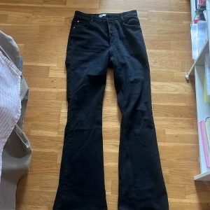 Svarta bootcut jeans från Zara - Säljer ett par svarta jeans från Zara med klassisk femficksdesign och bootcut-ben. Jeansen har en snygg, mörk ton och är tillverkade i jeansmaterial med en skön passform. Perfekta för dig som gillar en retro vibe och vill ha ett par jeans med lite extra sväng i benen.