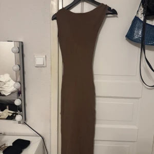 Figursydd klänning med hög slits - Aldrig använd. Klänning har en hög slits på sidan och är off shoulder på ena sidan 