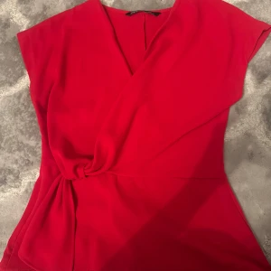 Röd omlottklänning från Zara XS - Snygg röd kortklänning från Zara i omlottmodell med knyt i midjan. Storlek xs, jätte fint skick priset kan diskuteras!