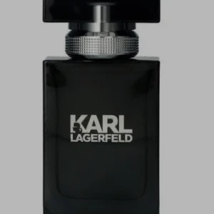 Karl Lagerfeld herrparfym svart flaska - Stilren parfym från Karl Lagerfeld i en svart, fyrkantig glasflaska med silverdetaljer och tydlig logga framtill. Flaskan har en robust känsla och modern design som sticker ut i badrumshyllan.