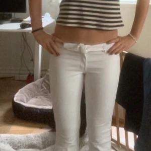 Vita utsvängda jeans från H&M  -  Byxorna har klassiska fickor fram och bak, samt dragkedja och knapp. Perfekta för dig som vill ha en fräsch och stilren look. Materialet är mjukt och stretchigt för extra komfort.