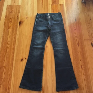 Mörkblå bootcut jeans Gina Tricot - Snygga mörkblå jeans från Gina Tricot i bootcut-modell. Jeansen har klassisk femficksdesign, broderade bakfickor och stängs med dubbla knappar. Tillverkade i mjukt denimtyg med lätt tvättad look. Perfekta för dig som gillar retrovibbar och bekväm passform.