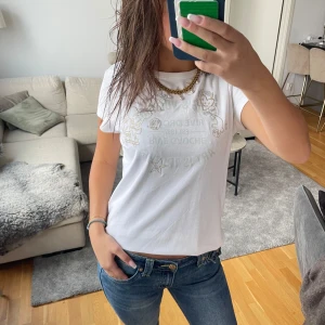 Zadig&Voltaire t-shirt - Vit t-shirt med coolt glittertryck och tecknade figurer framtill. Rund hals och korta ärmar. Skön passform och mjukt bomullsmaterial som känns nice mot huden. Perfekt för dig som gillar unika prints och vill sticka ut lite extra.